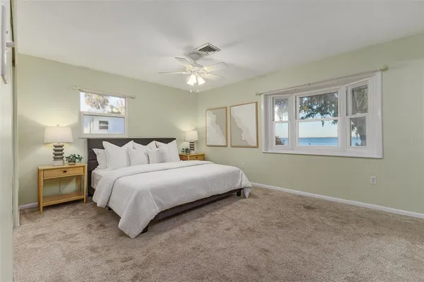 a spacious bedroom with a bed and a chandelier