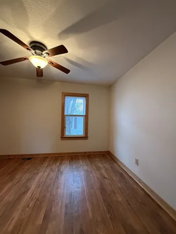 a view of an empty room with a chandelier fan
