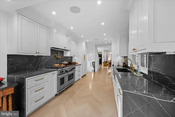 a large kitchen with stainless steel appliances lots of counter space and a sink