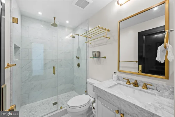 a bathroom with a sink a toilet and shower