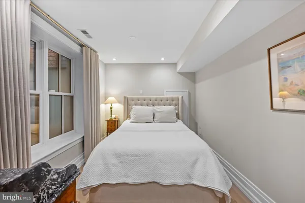 a large bed sitting in a bedroom next to a window