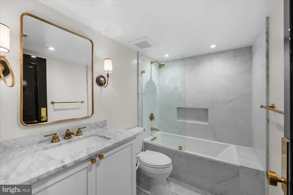 a bathroom with a granite countertop sink toilet and shower