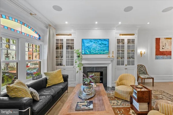 a living room with furniture fireplace and a large window