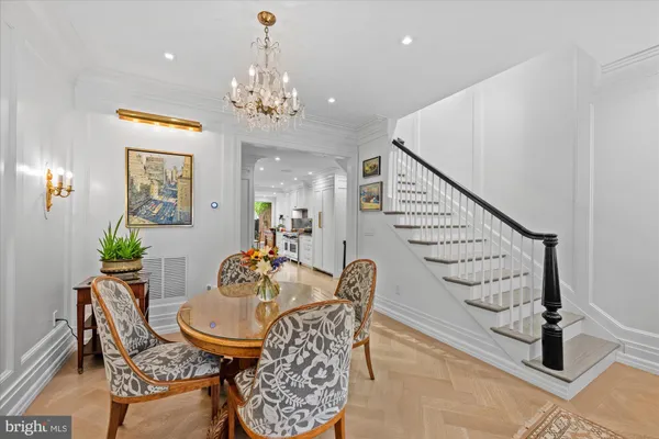 a dining room with furniture a chandelier and wooden floor