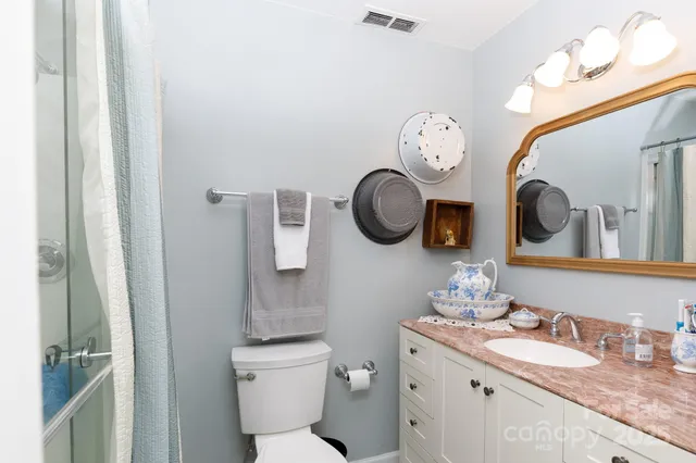 a bathroom with a toilet a sink and a mirror