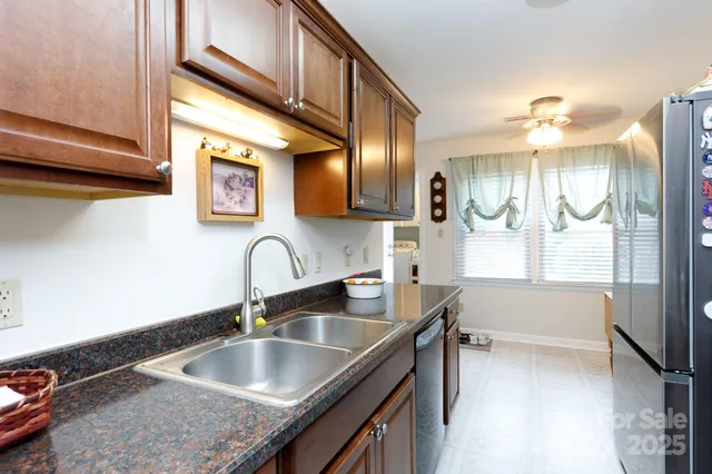 a kitchen with stainless steel appliances granite countertop a sink a stove and a refrigerator
