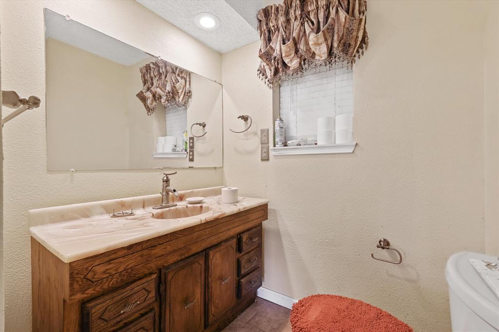 531 Private Road 4721 Rhome, TX 76078 - Photo 12 of 20 a bathroom with a sink mirror vanity and toilet