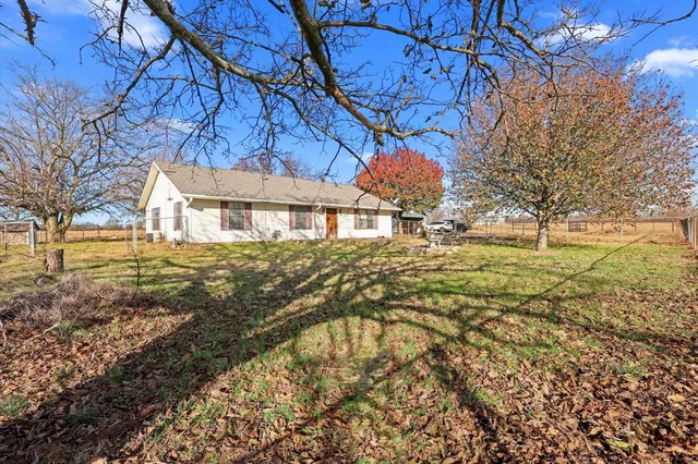 a view of a house with backyard and trees