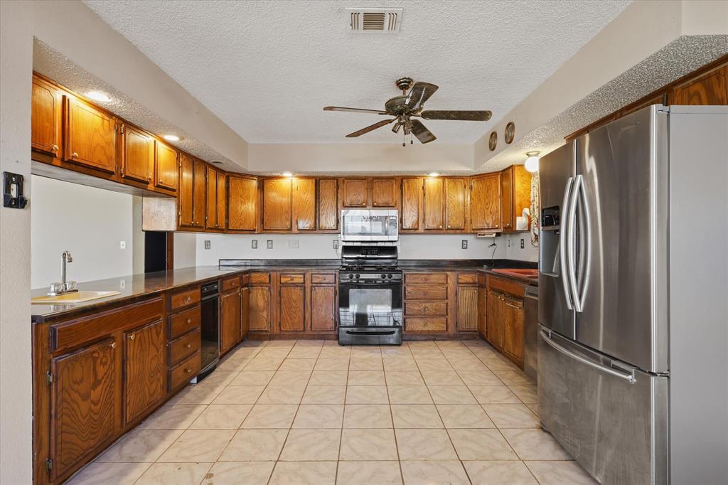 531 Private Road 4721 Rhome, TX 76078 - Photo 6 of 20 a kitchen with a refrigerator sink and cabinets