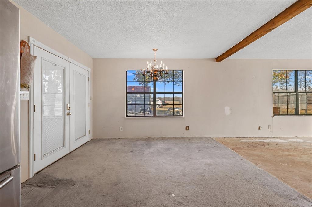 531 Private Road 4721 Rhome, TX 76078 - Photo 9 of 20 an empty room with windows and chandelier