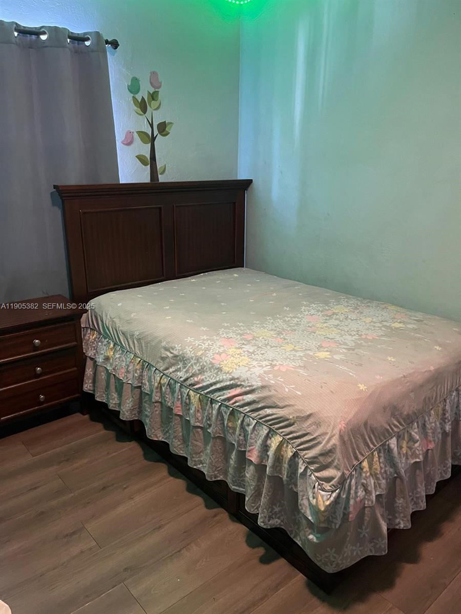 665 Northwest 153rd Street Miami, FL 33169 - Photo 12 of 28 a bedroom with bed and wooden floor