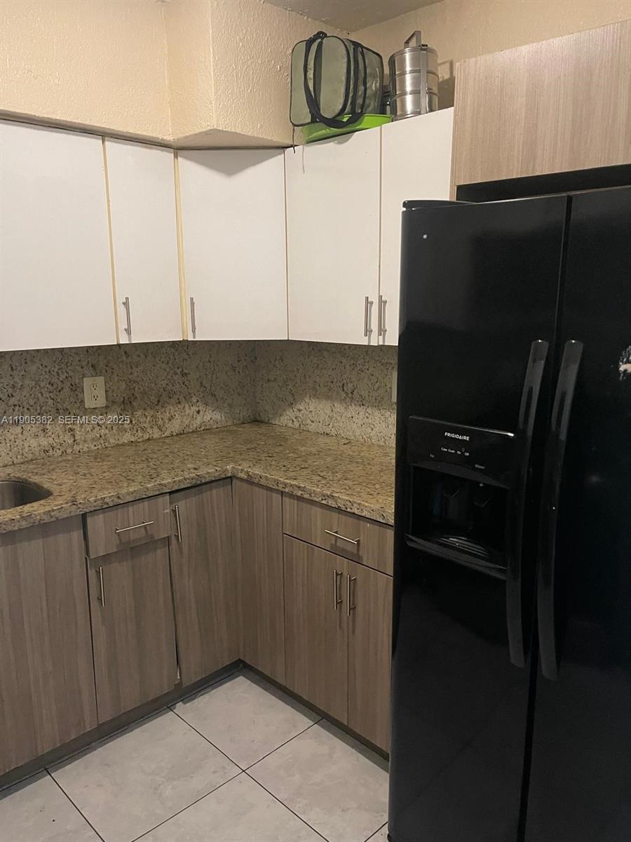 665 Northwest 153rd Street Miami, FL 33169 - Photo 24 of 28 a kitchen with a refrigerator and cabinets