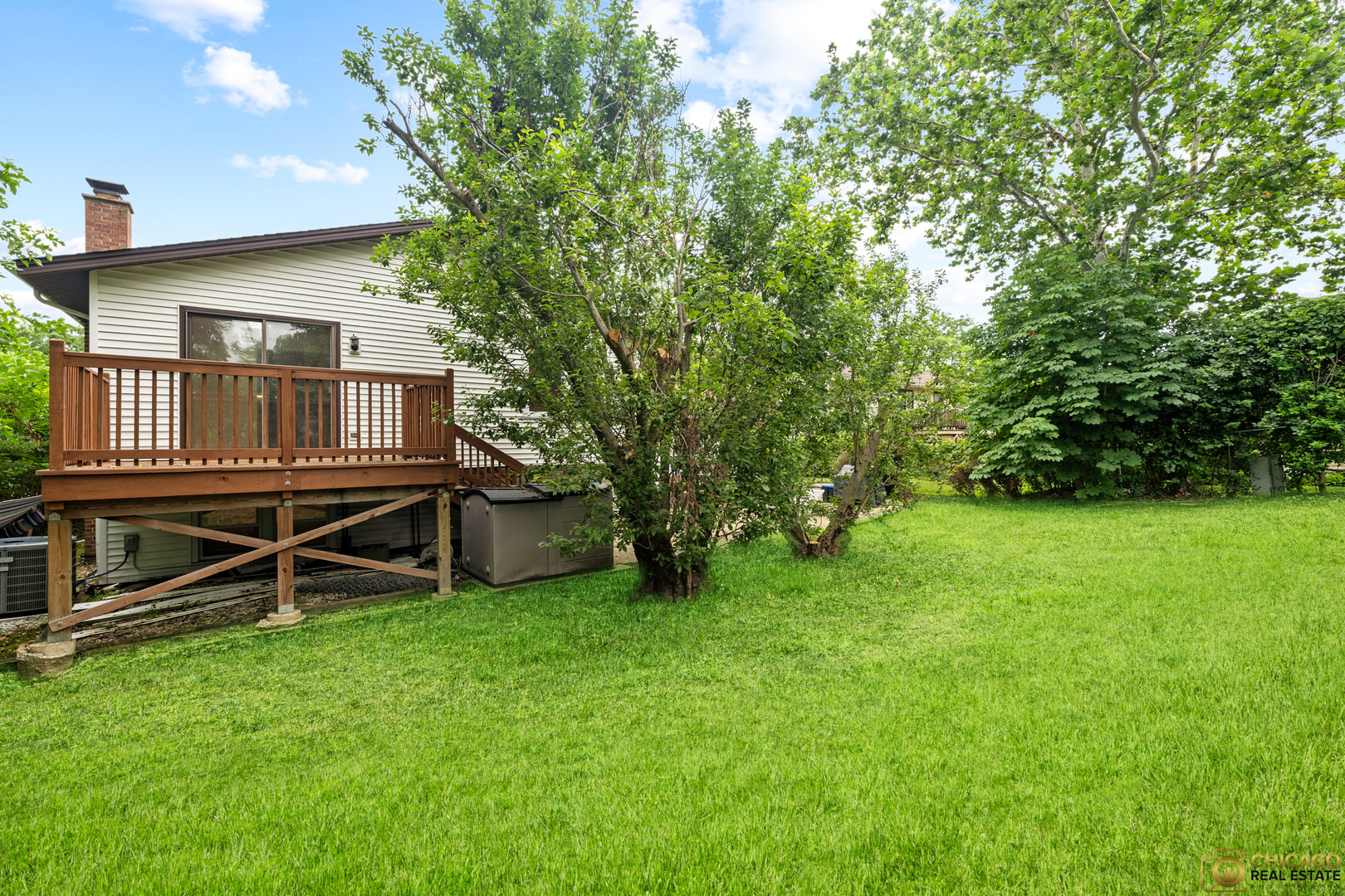 220 Osage Terrace Buffalo Grove, IL 60089 - Photo 10 of 24 a view of a house with a backyard and a wooden deck
