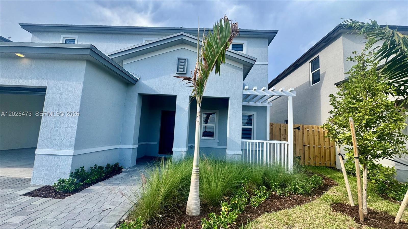 19479 Southwest 340th Street, Unit 1 Homestead, FL 33034 - Photo 3 of 58 a front view of a house with garden