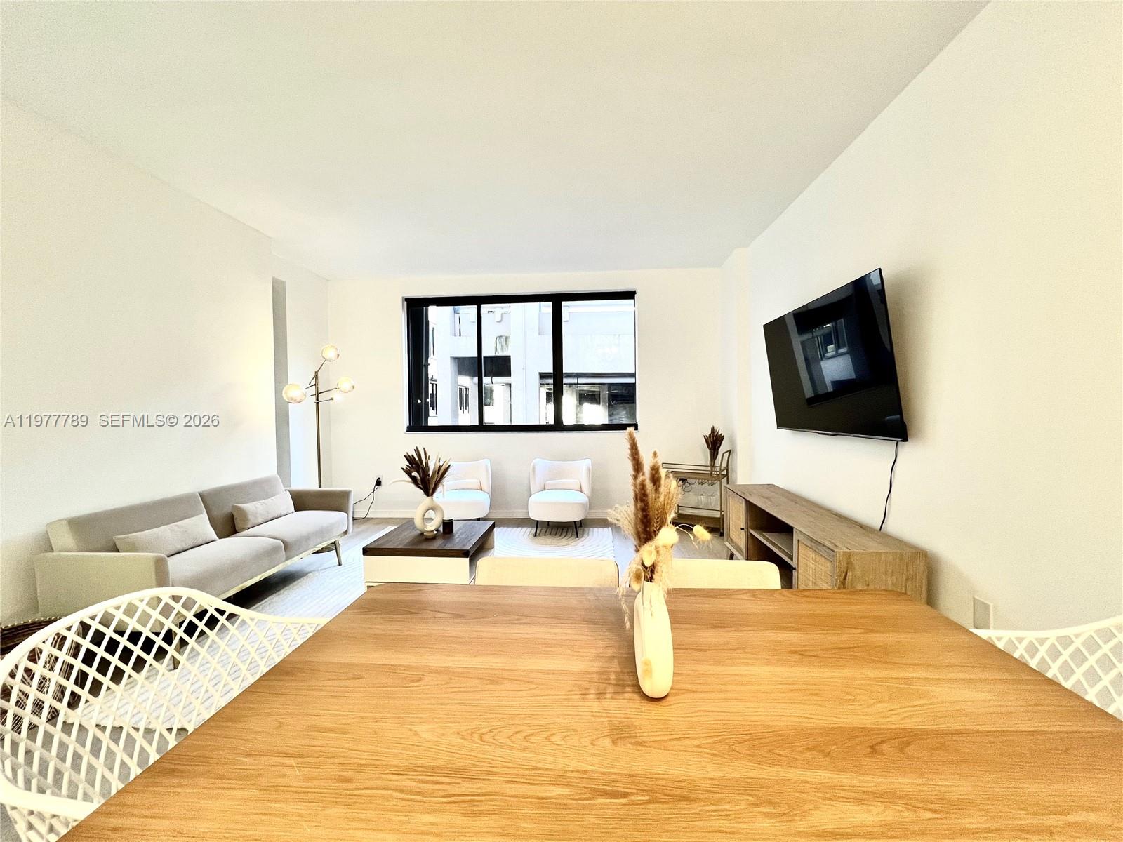 540 Brickell Key Drive, Unit 202 Miami, FL 33131 - Photo 12 of 25 a living room with furniture and a flat screen tv