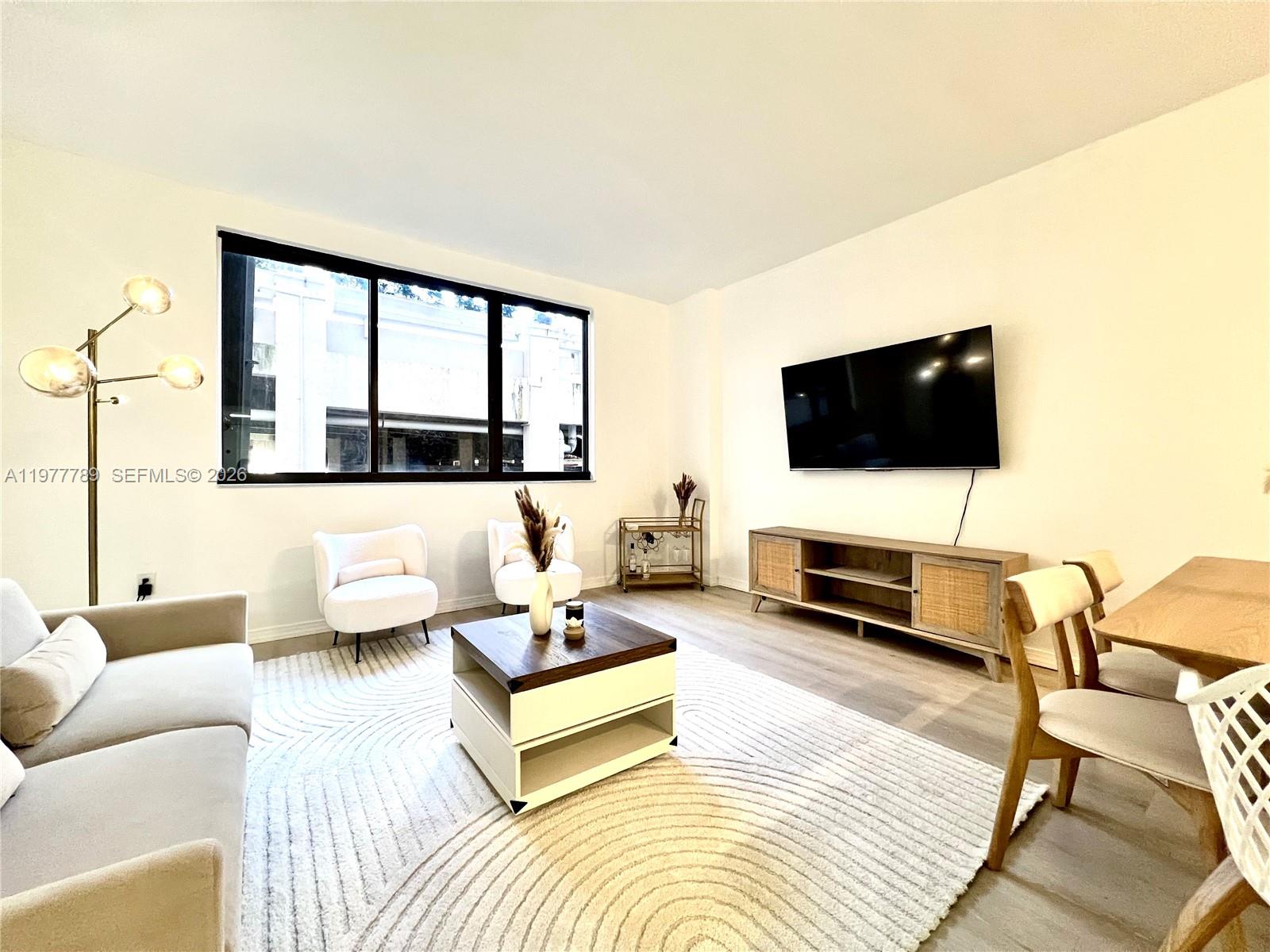 540 Brickell Key Drive, Unit 202 Miami, FL 33131 - Photo 10 of 25 a living room with furniture and a flat screen tv