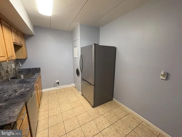 a kitchen with stainless steel appliances granite countertop a refrigerator and a stove