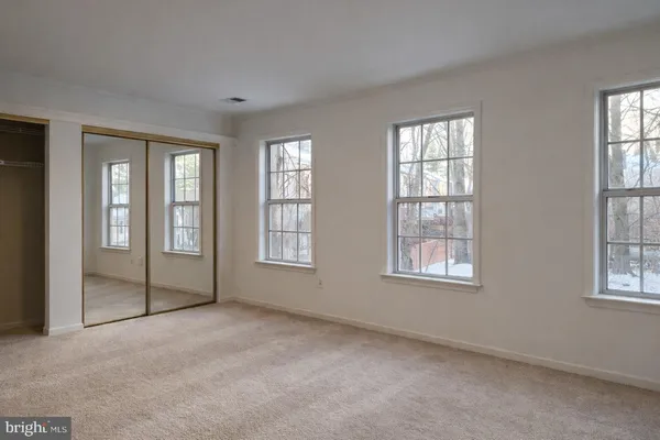 an empty room with windows and closet