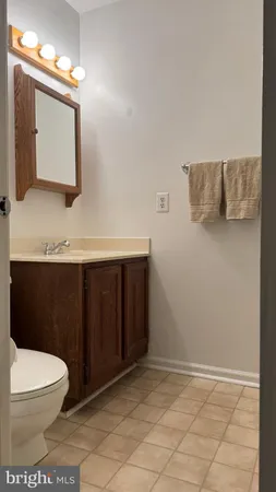 a bathroom with a toilet a sink and mirror
