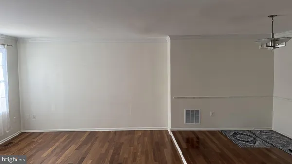 a view of a room with wooden floor and white walls