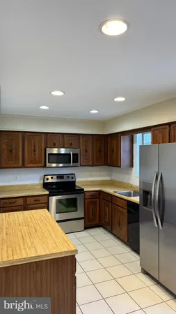 a kitchen with stainless steel appliances granite countertop a sink and stove top oven with wooden floor