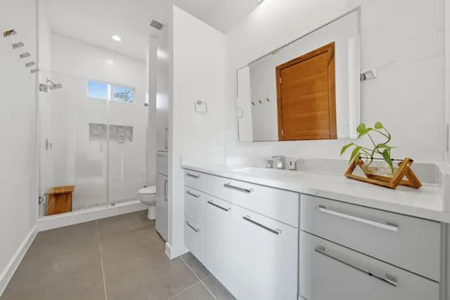 a bathroom with a sink a toilet and shower