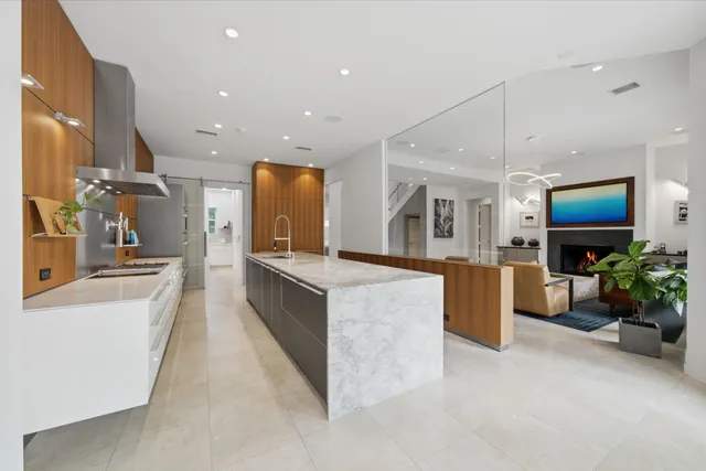 a large kitchen with stainless steel appliances kitchen island a large counter top and a view of living room