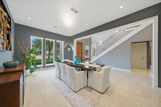 a living room with furniture and large windows