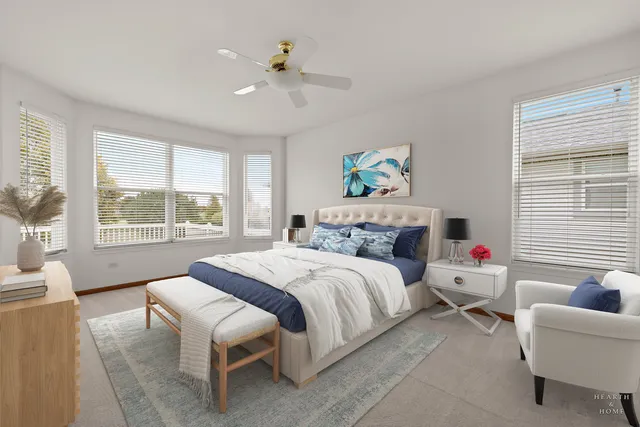 a bedroom with a bed a couch and a large window