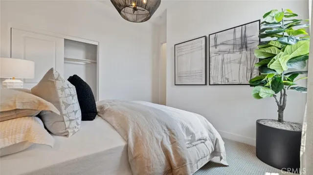 a bedroom with a bed lamp and a potted plant