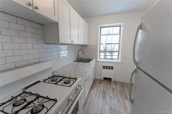 a kitchen with a stove a sink and a window
