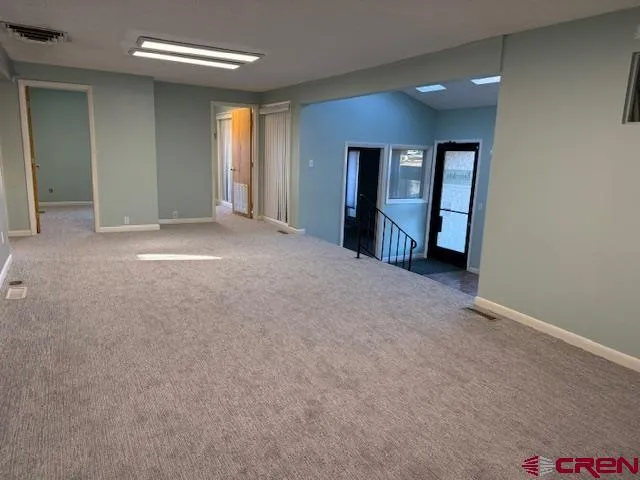 an empty room with window and bathroom