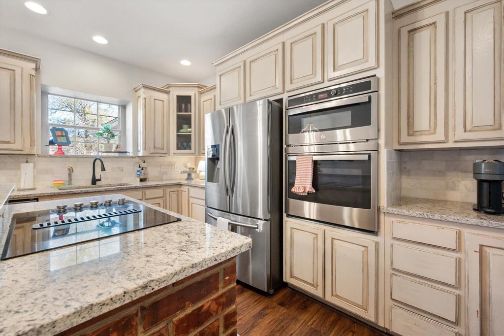 100 Ruth Court Aledo, TX 76008 - Photo 22 of 40 a kitchen with stainless steel appliances granite countertop a refrigerator and white cabinets