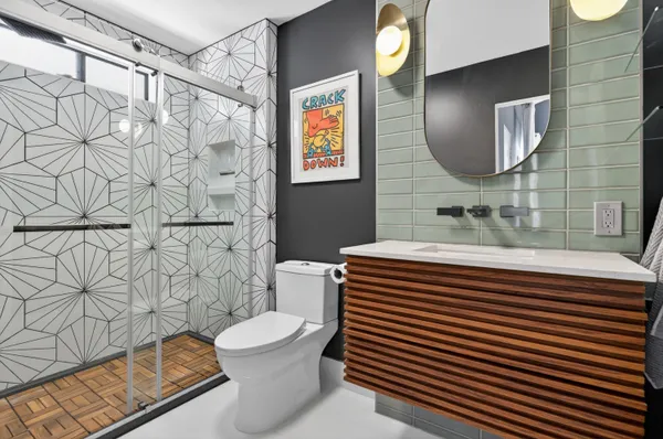 a bathroom with a sink a toilet and mirror