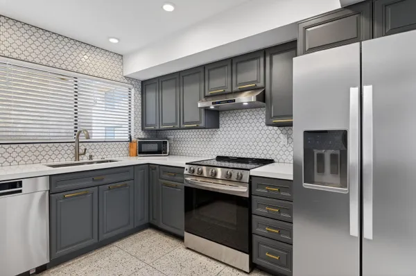 a kitchen with a stove sink and refrigerator