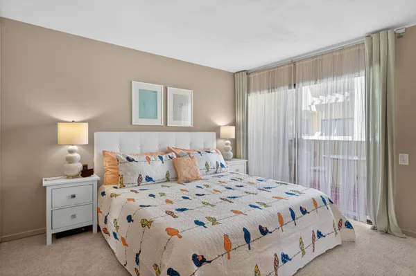a bedroom with a bed and large windows