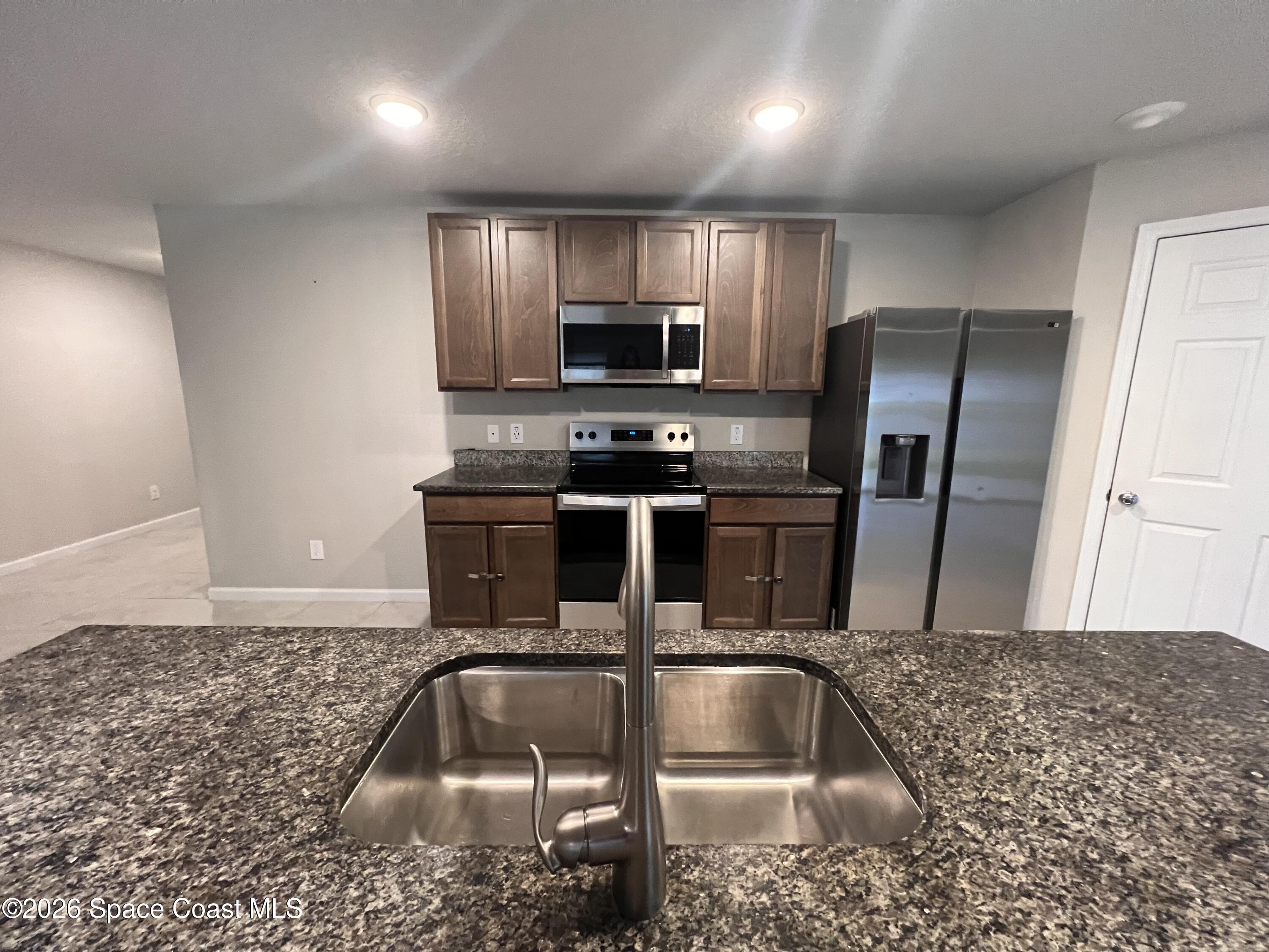 545 Cooper Court Palm Bay, FL 32908 - Photo 14 of 19 a kitchen with kitchen island a sink stainless steel appliances and a counter top space