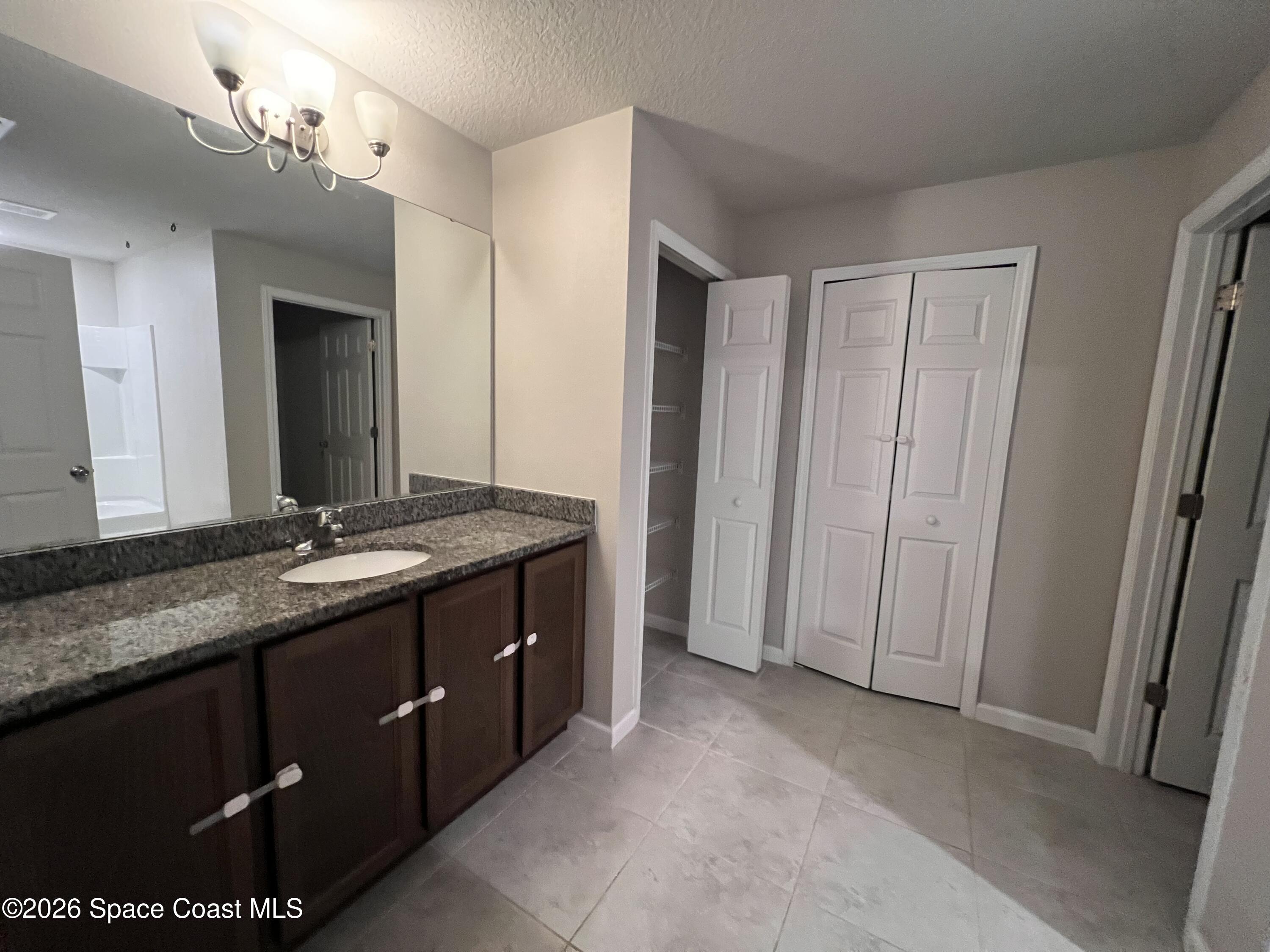 545 Cooper Court Palm Bay, FL 32908 - Photo 17 of 19 a bathroom with a granite countertop sink and a mirror