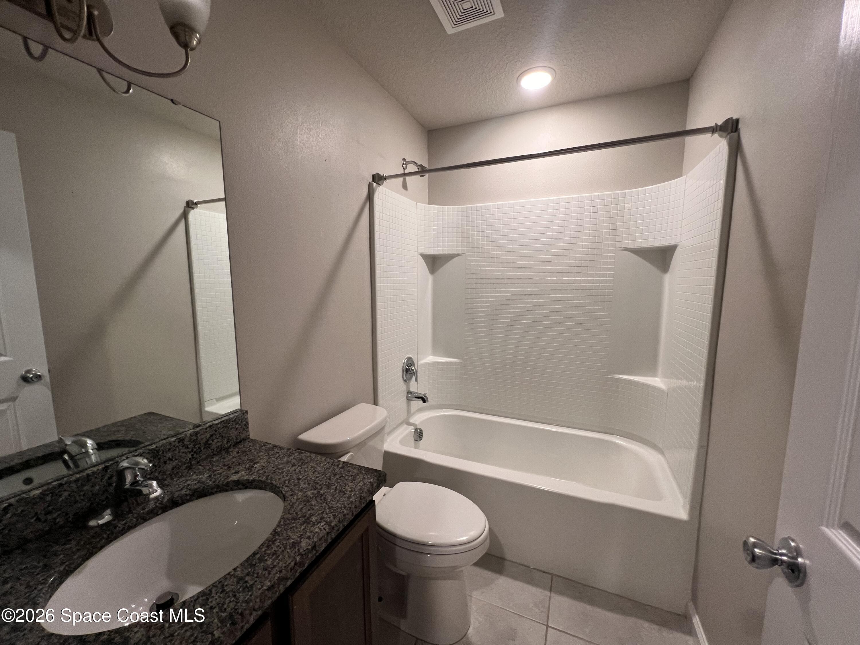 545 Cooper Court Palm Bay, FL 32908 - Photo 5 of 19 a bathroom with a granite countertop sink toilet and shower