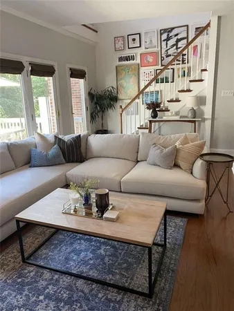 a living room with furniture and a wooden floor
