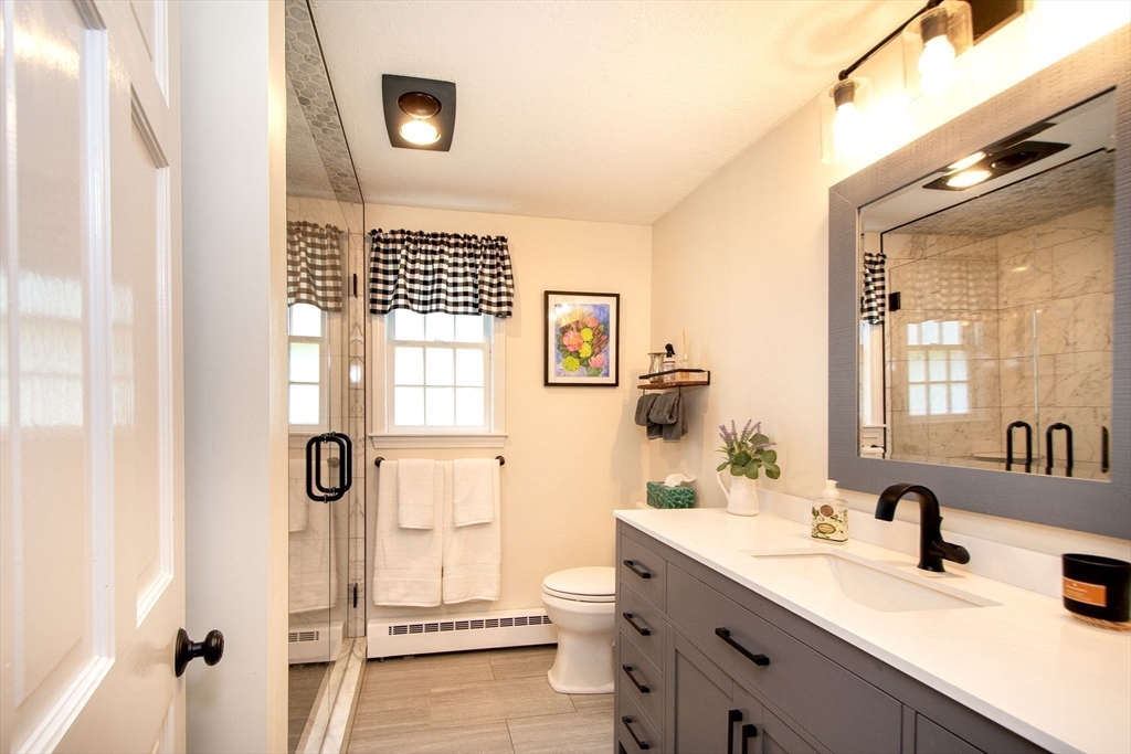 21 Flintlock Ridge Road Cohasset, MA 02025 - Photo 11 of 28 a bathroom with a sink a mirror and a shower