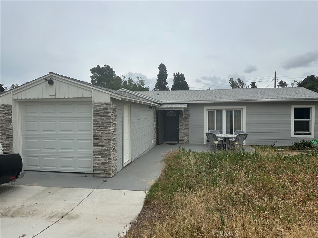 310 Santa Rita Place Banning, CA 92220 - Photo 1 of 27 a view of a house with a yard and garage