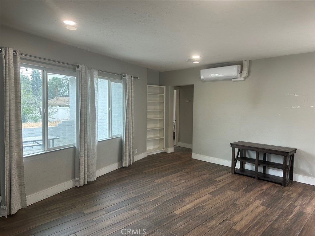 310 Santa Rita Place Banning, CA 92220 - Photo 6 of 27 an empty room with wooden floor and windows