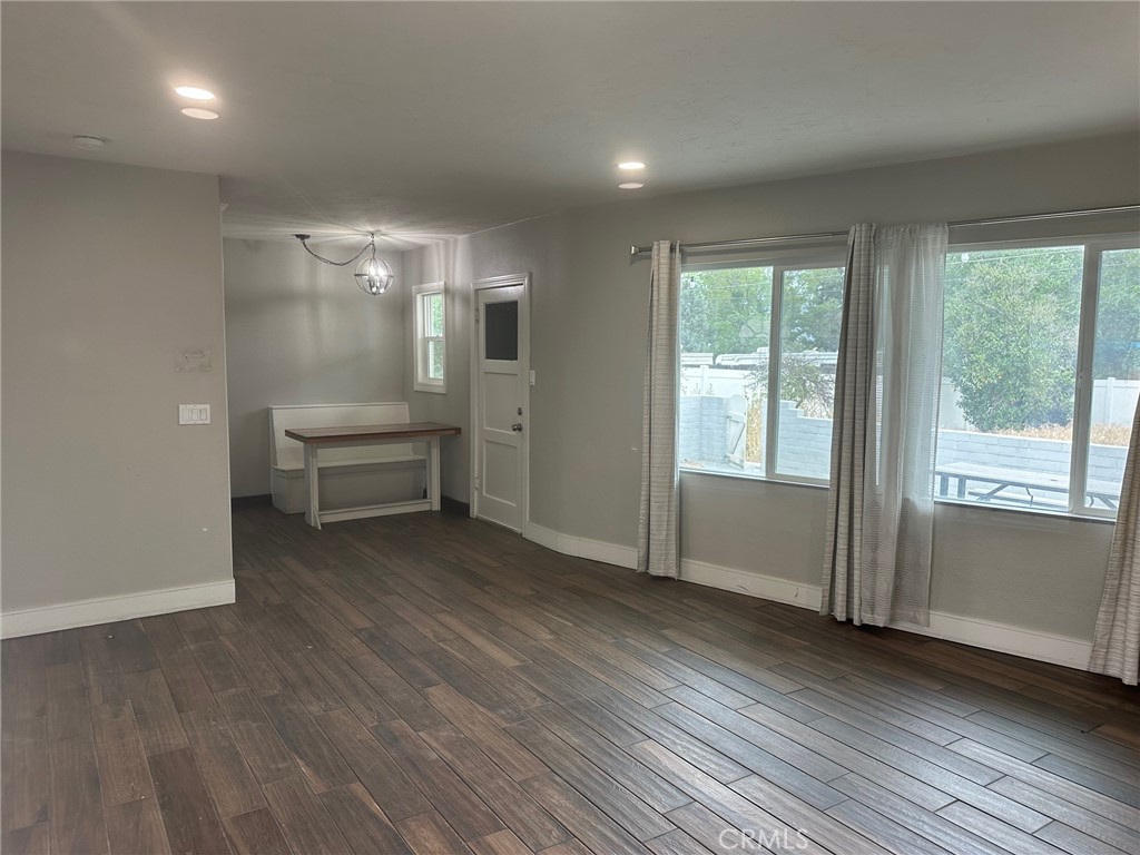 310 Santa Rita Place Banning, CA 92220 - Photo 7 of 27 an empty room with wooden floor and windows