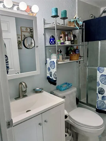 a bathroom with a sink a toilet and a shower curtain