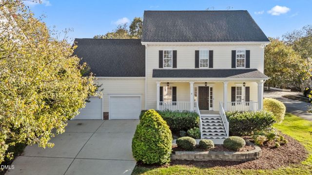 a view of a house with a yard and potted plants