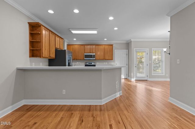 a view of an empty room with a window and chandelier