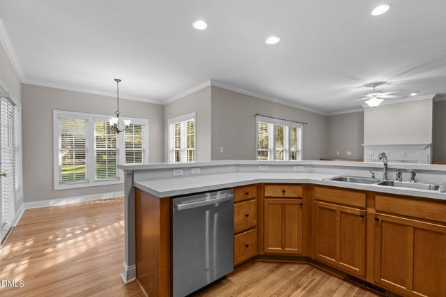 a kitchen with stainless steel appliances granite countertop a refrigerator a sink and a stove with wooden floors