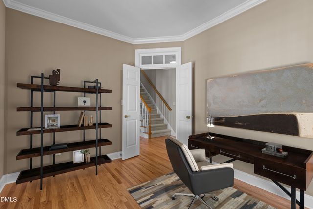 a view of an empty room with wooden floor and stairs