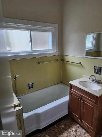 a bathroom with a tub sink and cabinets
